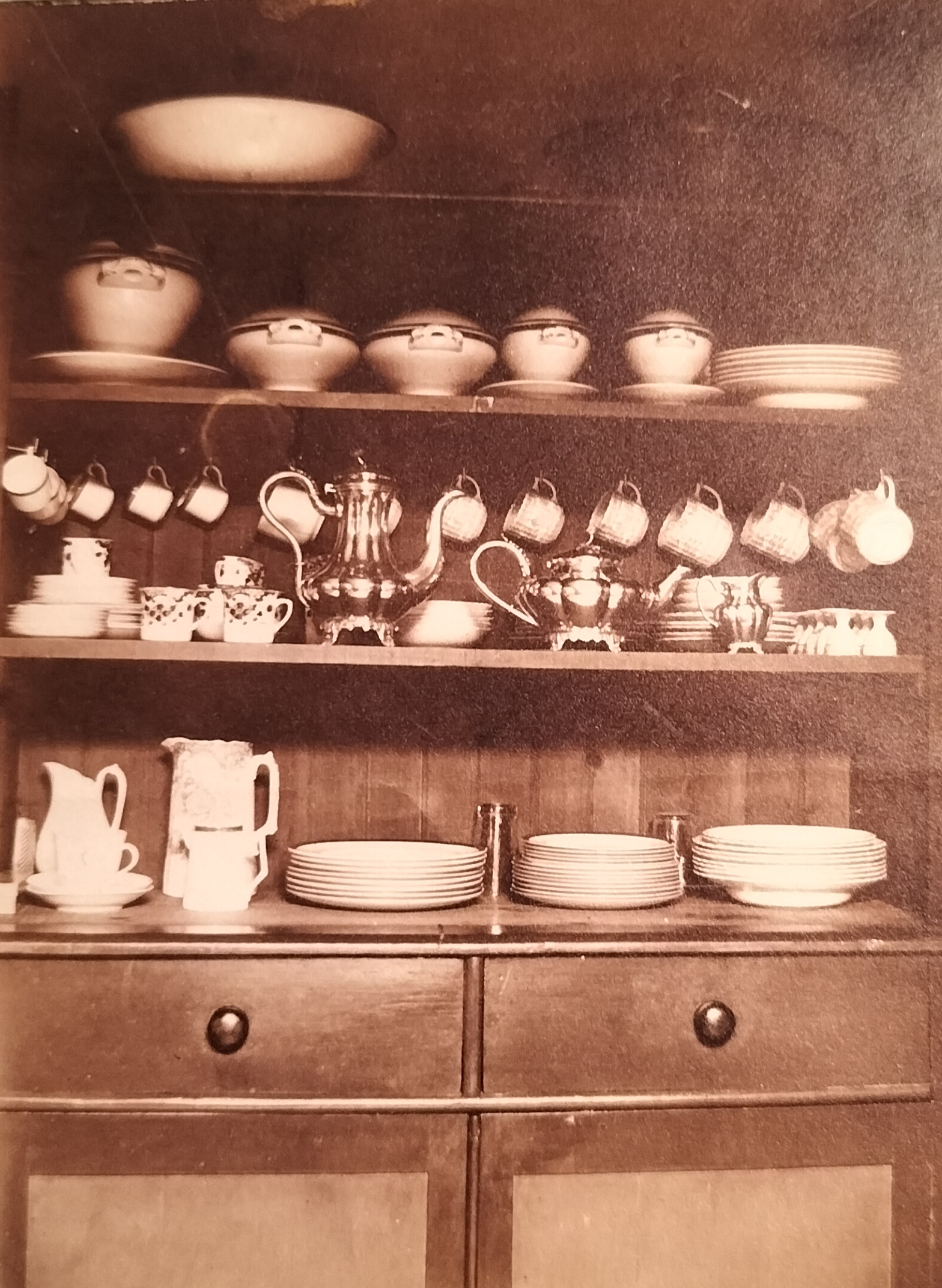 Another corner of the kitchen showing a variety of plate lids. Although heavily blurred due to the harsh light, the item standing on the left is a Victorian knife cleaner – this in itself is indicative that it was a well-to-do family who stayed in the house.