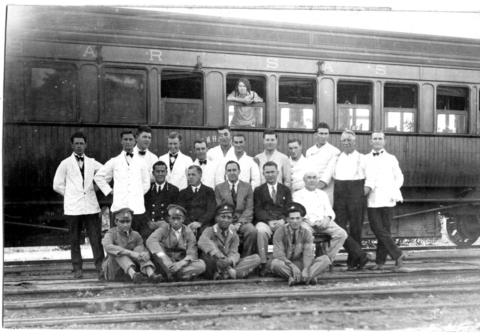 Train staff pose with a dining car in the 1930s